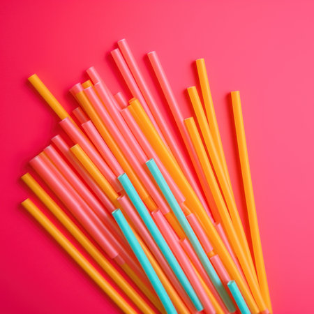 A group of orange and blue straws on a pink background. AI generative image.の素材