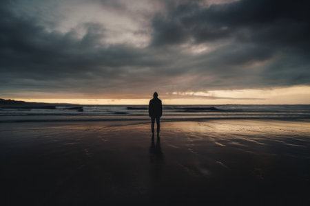 A person standing on a beach at sunset. AI generative image.の素材