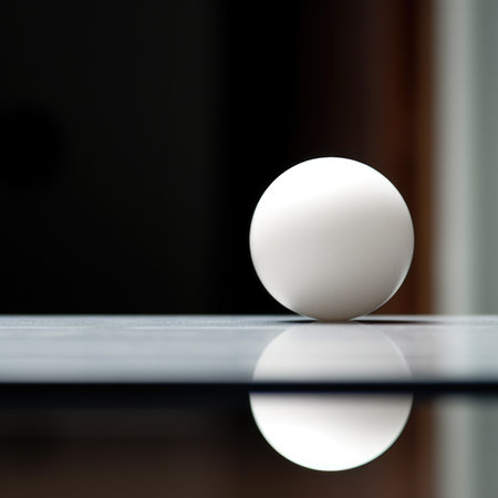 A white ball sitting on a table with a reflection, AIの素材