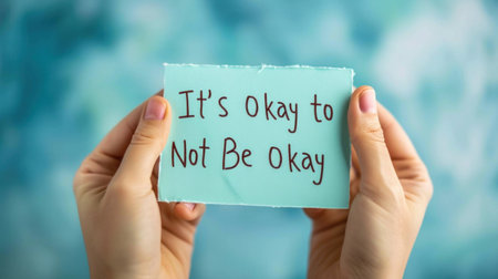A person holding a piece of paper that says its okay to not be ok, AIの素材