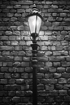 A street light is lit up against a brick wall, AIの素材