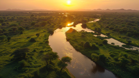 A river runs through a lush green landscape at sunset, AIの素材