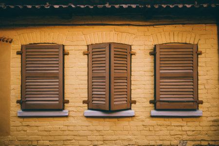 A brick wall with three windows and a clock on it, AIの素材