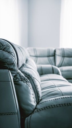 A close up of a leather couch in the corner of an empty room, AIの素材