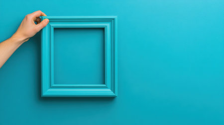 A hand holding a blue frame against the wall, AIの素材