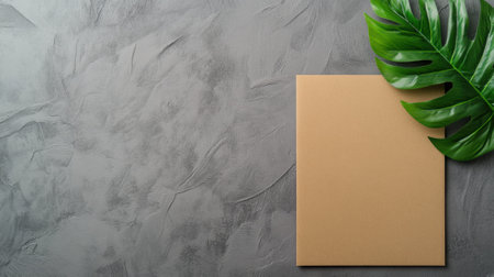 Brown paper sheet on textured gray surface with a green leaf accent, AIの素材