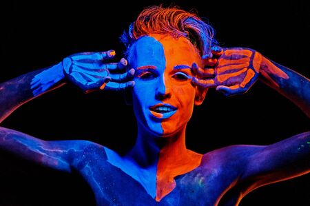 Man covered with fluorescent paint playing in the dark
