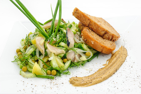 Marinated herring with greenery, mustard and fried bred isolated on whiteの写真素材