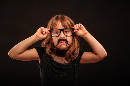 Young girl at Halloween party with spectacles and fake mustacheの写真素材