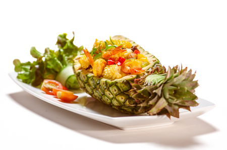 Fried squid with rice served in pineappleの写真素材