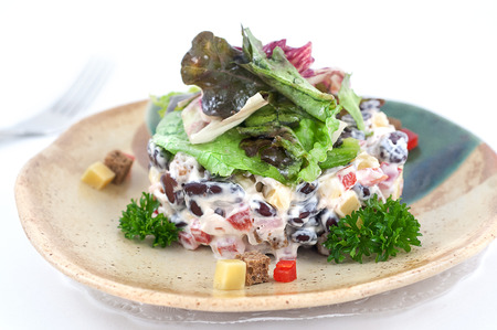Mixed salad with dressingand greenery isolated on whiteの写真素材