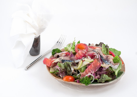 Mixed salad with dressingand greenery isolated on whiteの写真素材