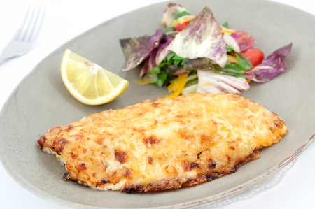 Piece of fishe fillet backed with cheese isolated on whiteの写真素材