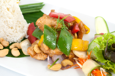 Fried chicken with cashew nuts and paprica isolated on whiteの写真素材