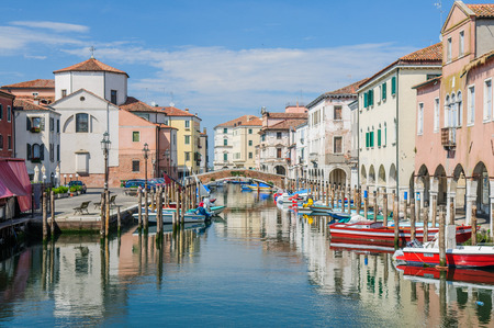 View over channel witn boats, houses and reflections in Chioggiaのeditorial素材