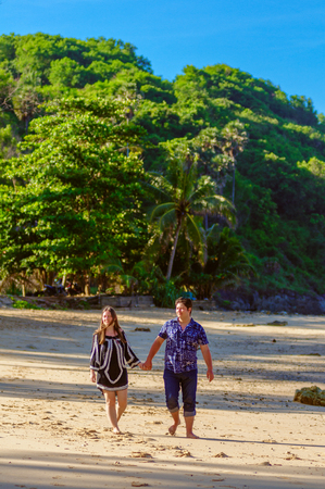 Joyful honeymoon couple playing on a beach in Phuket, Thailandの写真素材