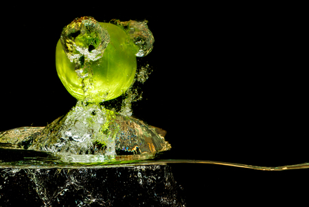Apples in water with reflrction and splash on black backgroundの写真素材