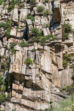 NAtural stone walls with cracks filled with grass in summerの写真素材