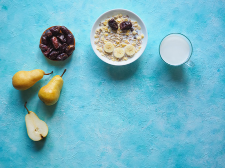 Traditional european breakfast. Milk and granola. Muesli, dates and fresh pearsの写真素材