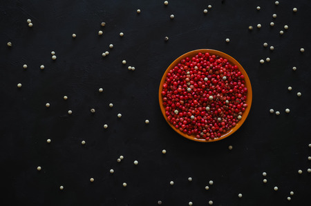 Pink pepper peas on a black background. Top view.の写真素材