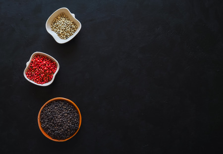 Spices: black pepper, pink pepper and white pepper in a bowl. The view from the top.の写真素材