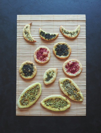 Herb scones with spices on a bamboo napkin on a black table.の写真素材