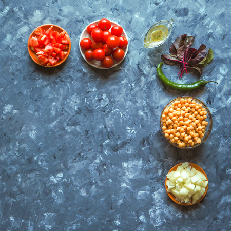 Chickpeas and cherry tomatoes on grey kitchen table.の写真素材