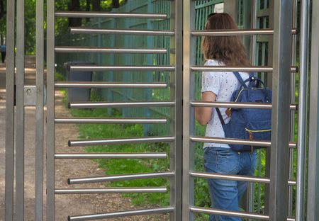Lady with a backpack turnstiles in a private Park