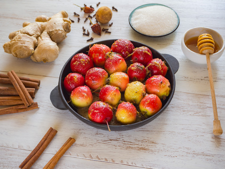 Raw apples in a pan with sweet syrup of honey, ginger, cloves and cinnamon before baking in the ovenの写真素材