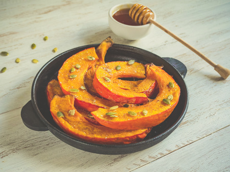 Dessert with baked pumpkin slices on a white rustic tableの写真素材
