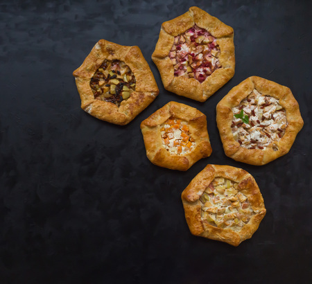 Pattern of different handmade pies on a black kitchen table