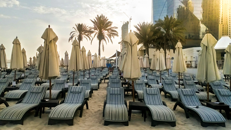 Beach with umbrellas in Dubai in the evening.