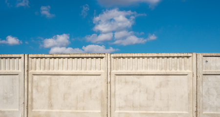 Concrete fence against the cloud blue sky