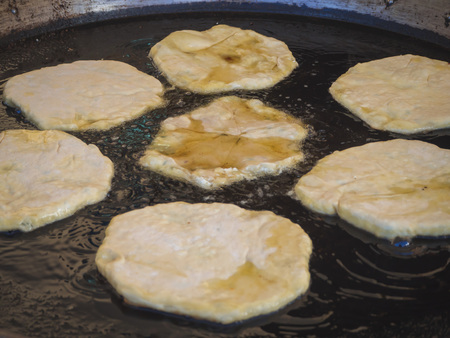 Romanian traditional pies are fried in a large frying pan