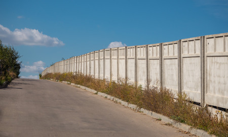 The perspective of a concrete fence. Concrete fence against the blue skyの写真素材