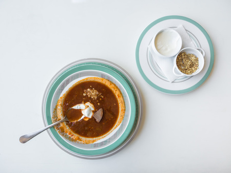 Meat soup kharcho with nuts and sour cream on a white tableの写真素材