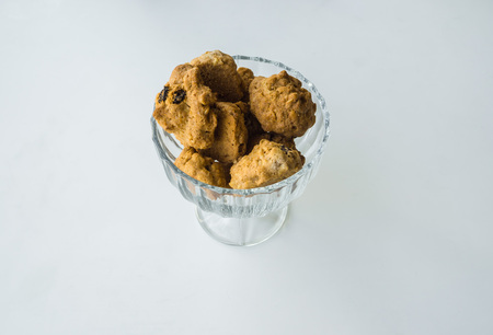 Cookies in a glass vase on a white tableの写真素材