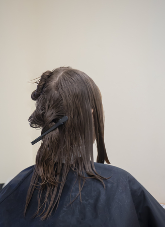 A woman with wet hair before a haircutの写真素材