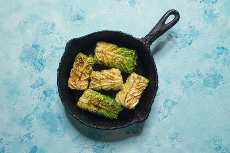 Fresh appetizing cabbage rolls tied with string and served on cast iron pan.の写真素材