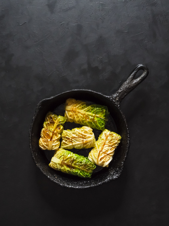 Cabbage rolls tied with string and served on a pan on black background.の写真素材