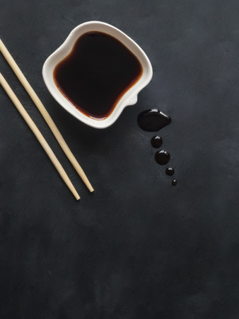 Chopsticks and soy sauce on black background. Top view.の写真素材