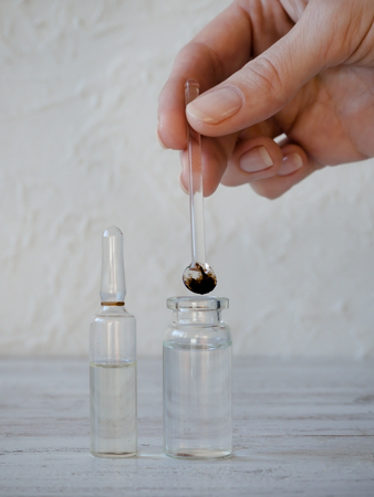 Scientist hand holding the glass rod with the drug. Laboratory studies.