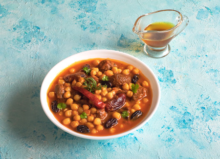 Stewed meat with bulgur and chickpeas in red sauce with dates and raisins.