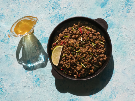 Indian minced meat Qeema on a sunny blue table. Top view.