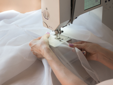 Hand sews a tulle on the sewing machine. Close up.の写真素材