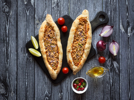 Arabic pizza Lahmacun on dark wooden background
