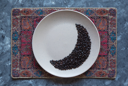 Coffee beans in moon shape on a plate. Ramadan concept.