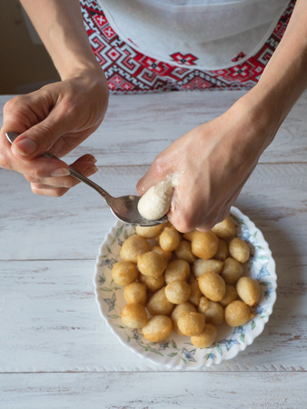 Preparation of traditional Greek sweets Loukoumades from dough with honey syrup.の写真素材
