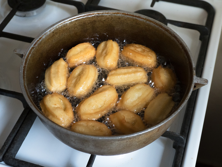 Tulumba - arabian syrup-soaked fried sponge honey are prepared on the stove, fried in oil.