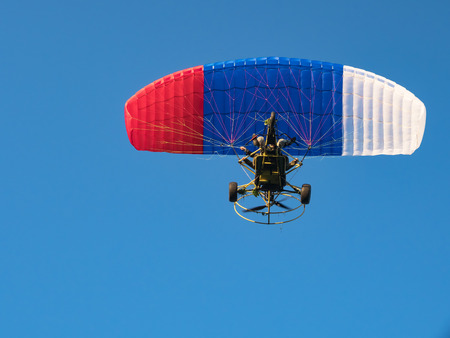 Extreme sports. Powered parachute against the blue sky.